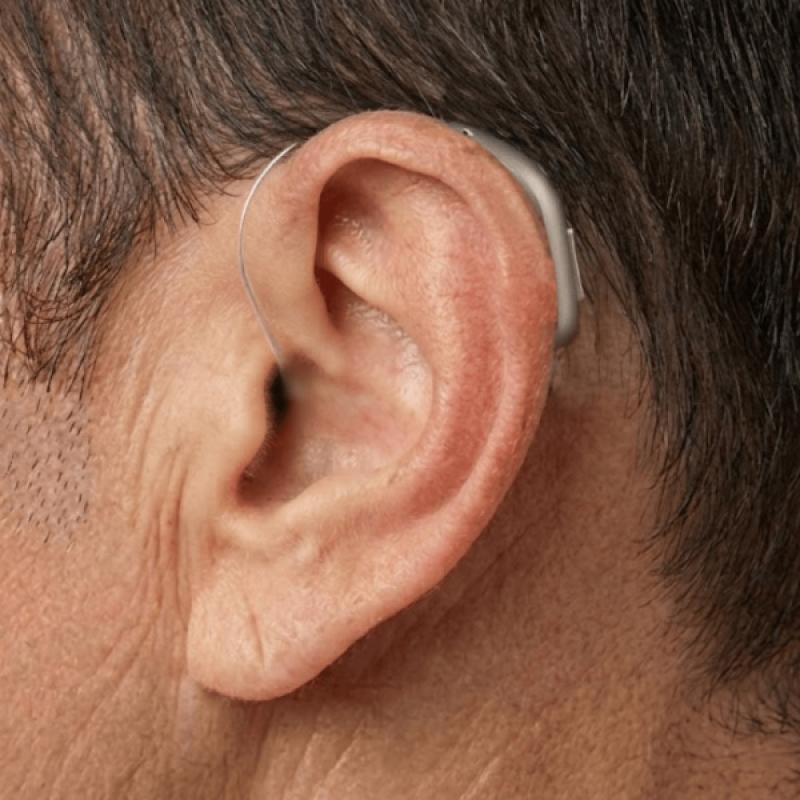 Hombre usando audífono RITE discreto detrás de la oreja - Foto real de uso diario