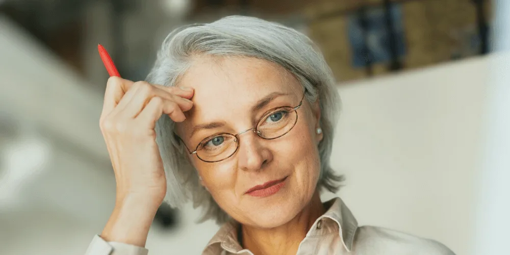 Persona mayor sonriendo mientras usa un audifono moderno