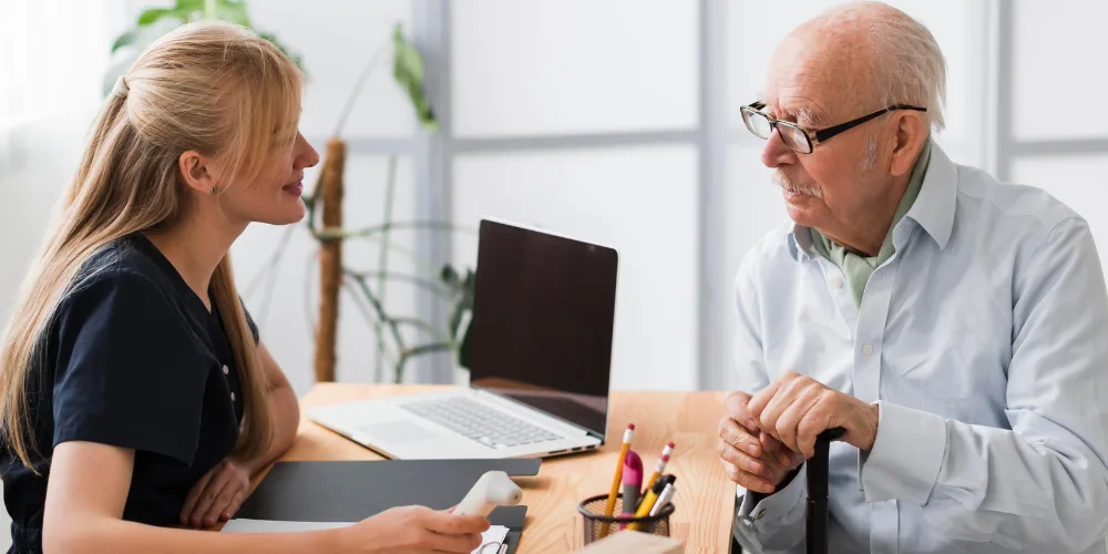 Persona mayor siendo atendida por una audiologa