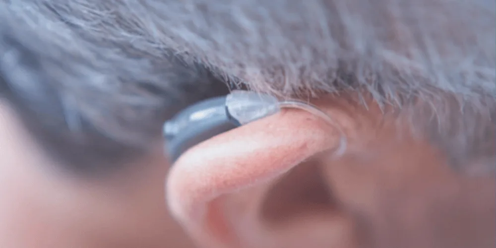 Usuario aprendiendo a colocar su nuevo audifono correctamente